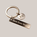 Personalised engraved keyring with bar tag and initial charm — Custom keyring featuring an engraved rectangular bar tag with your chosen message and a round disc charm with your initial, including 11 motivational stock designs or your own wording.